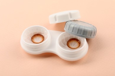 Photo of Case with color contact lenses on beige background