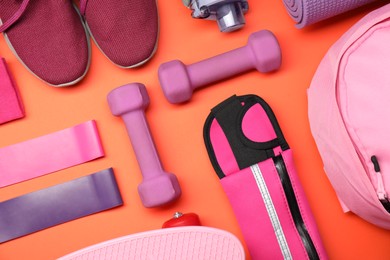 Different sports equipment on orange background, flat lay