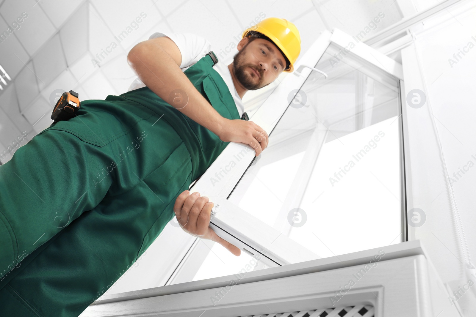 Photo of Construction worker installing new window in house