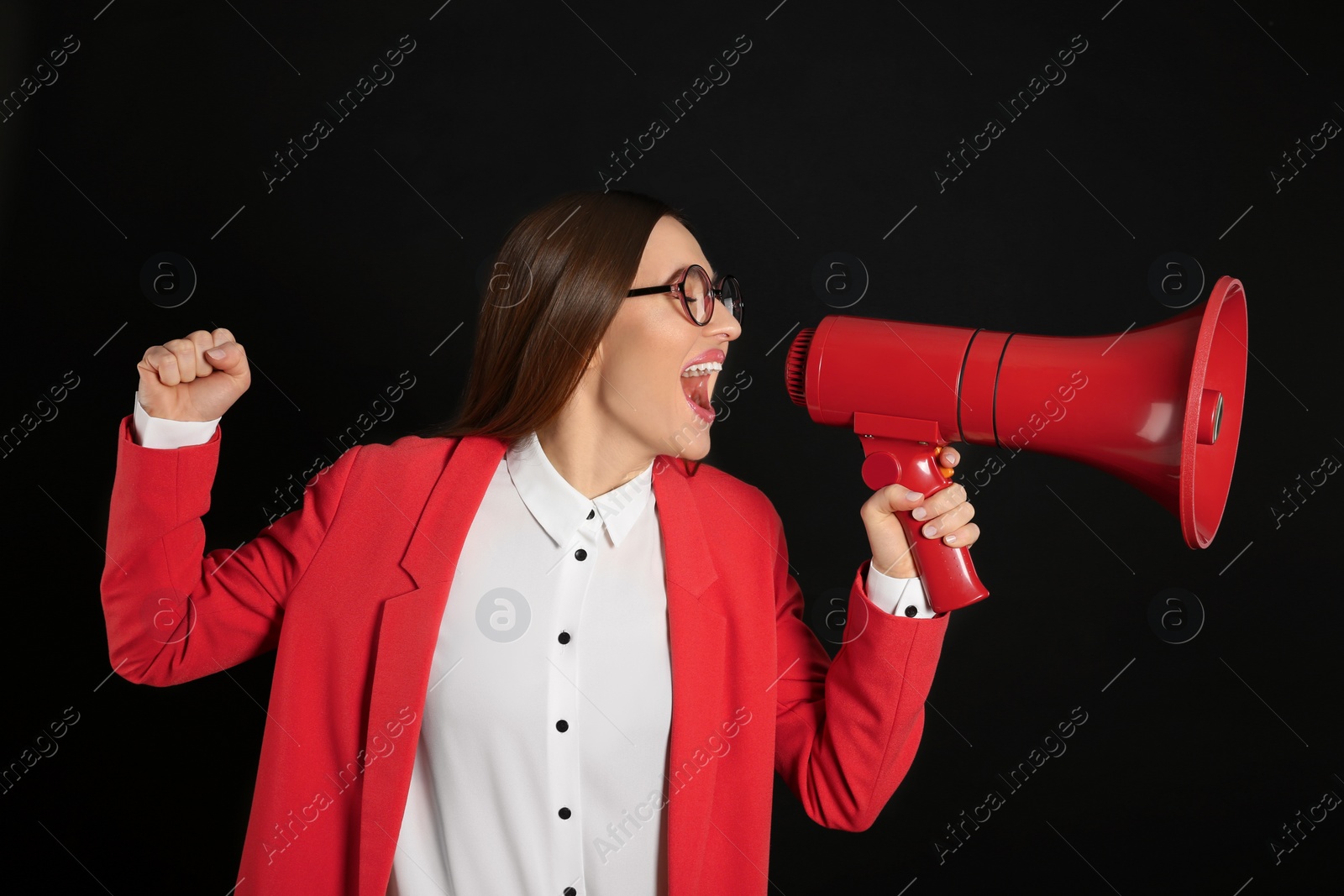 Photo of Young woman with megaphone on black background