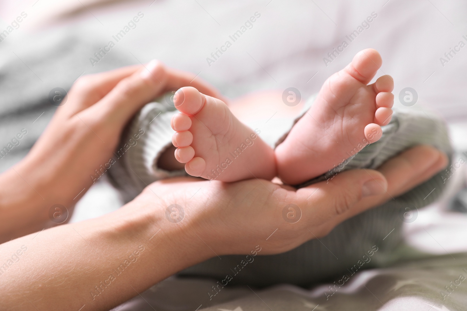 Photo of Mother and her newborn baby on bed, closeup