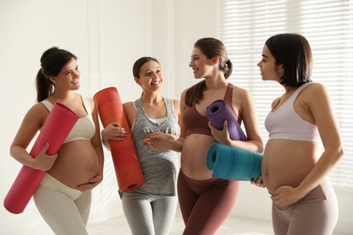 Photo of Group of pregnant women with mats in yoga class