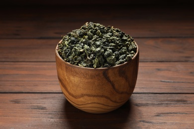 Photo of Bowl of Tie Guan Yin oolong tea leaves on wooden table