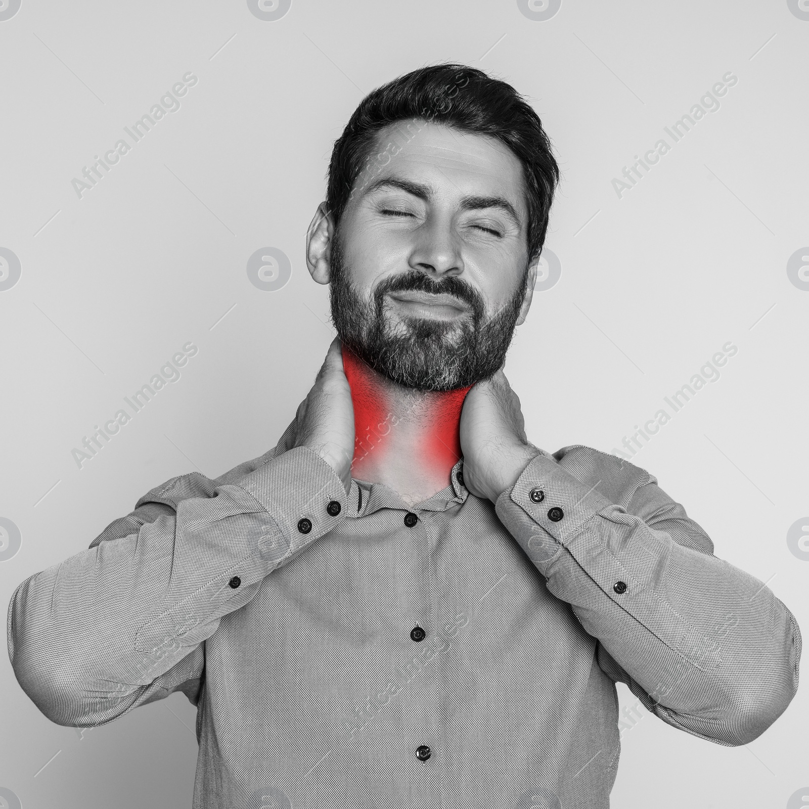 Image of Man suffering from rheumatism on light background. Black and white effect with red accent in painful area