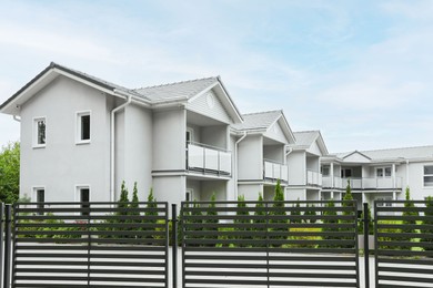 Photo of Beautiful view of white houses behind fence