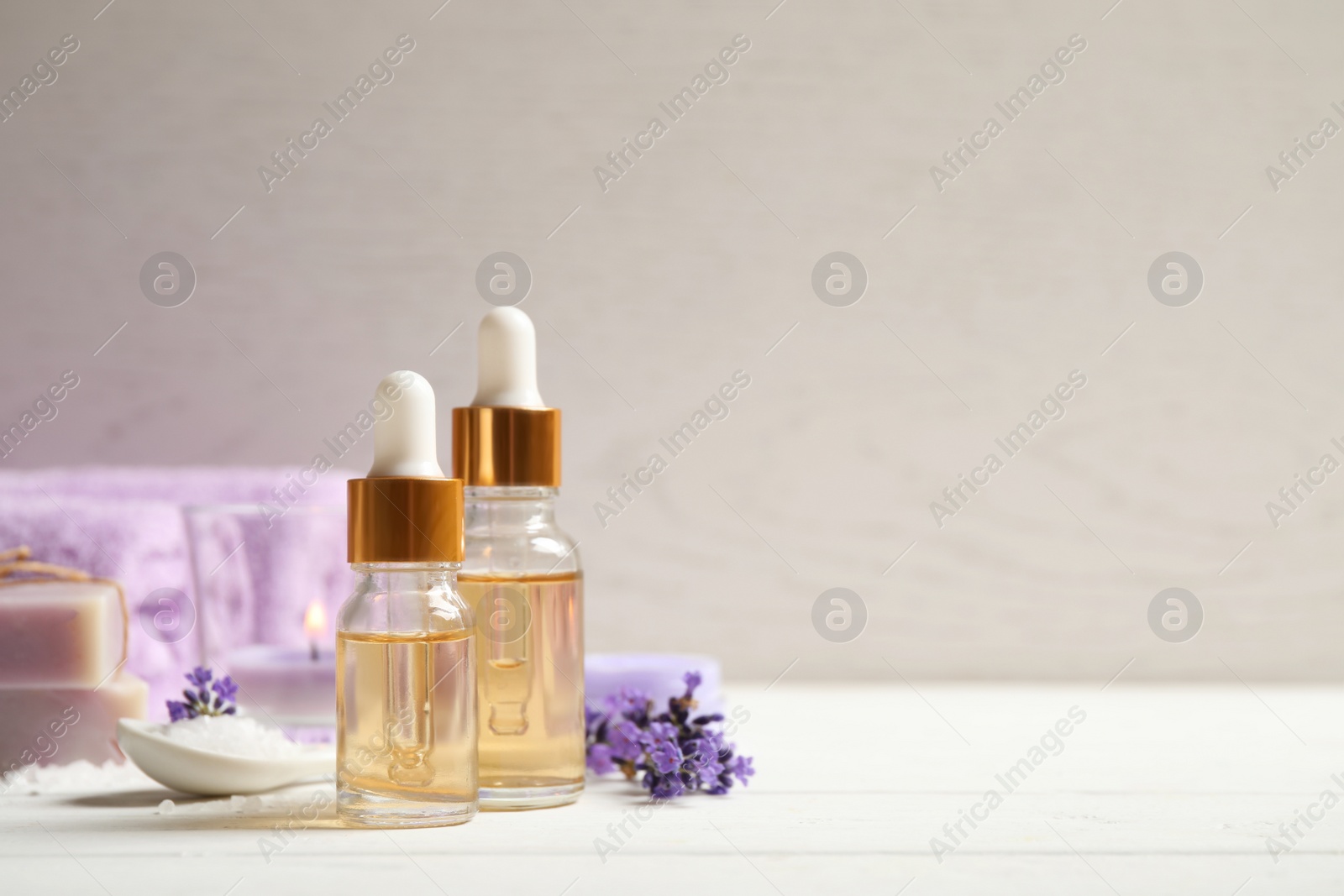 Photo of Composition with bottles of lavender essential oil on white wooden table. Space for text