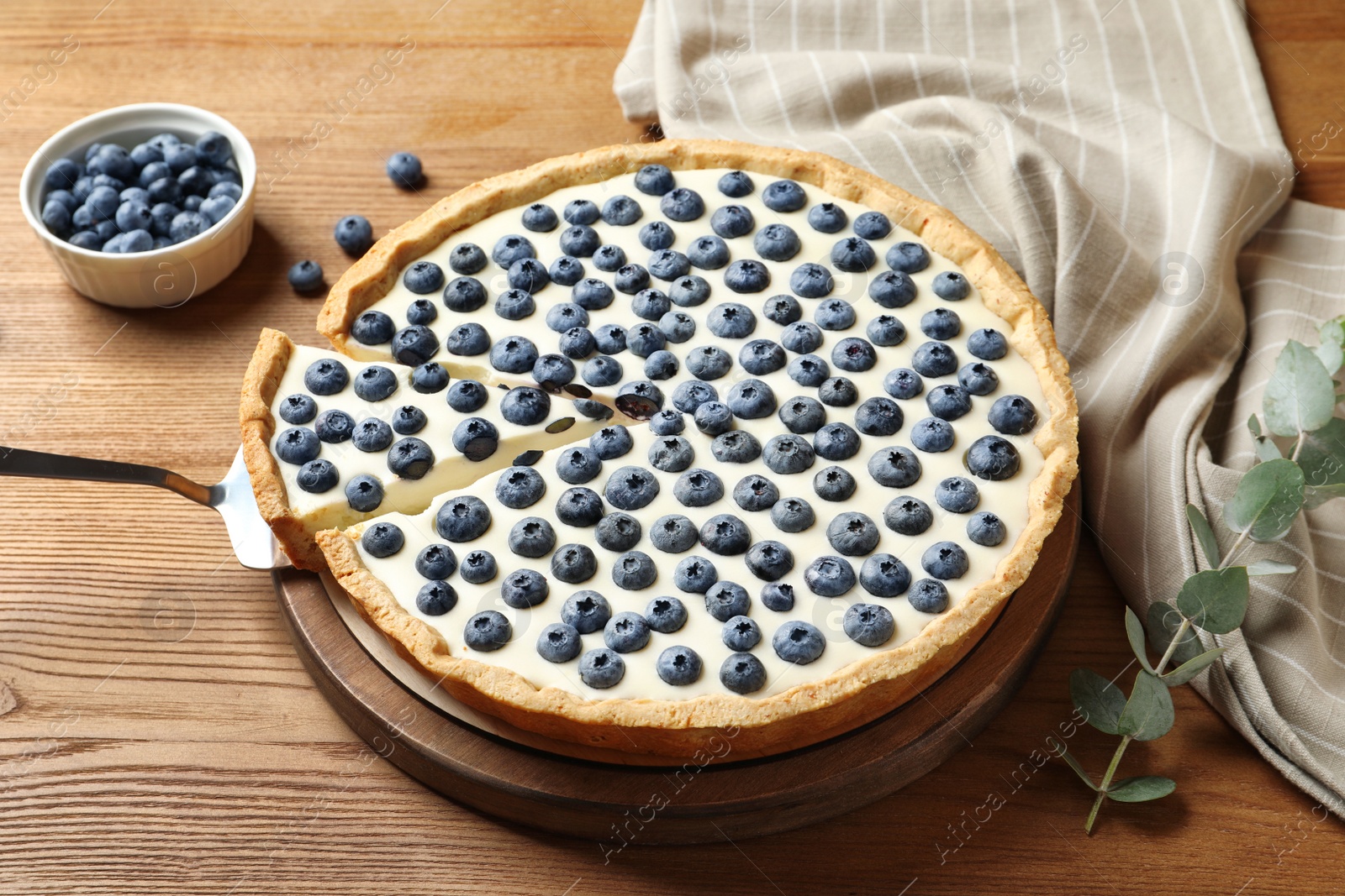 Photo of Tasty cake with blueberry on wooden table