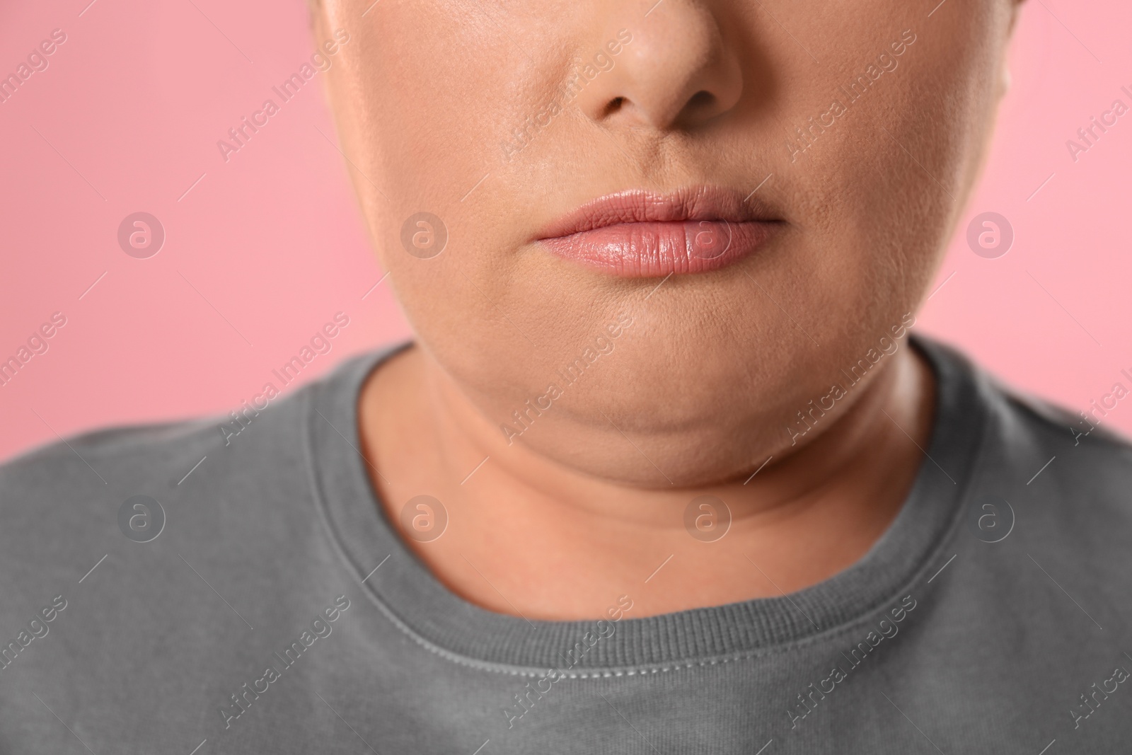 Photo of Woman with double chin on pink background, closeup