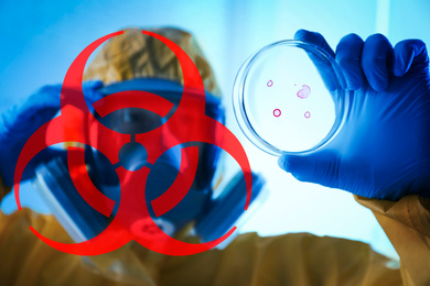 Image of Poison sign and scientist holding Petri dish in laboratory, focus on hand 