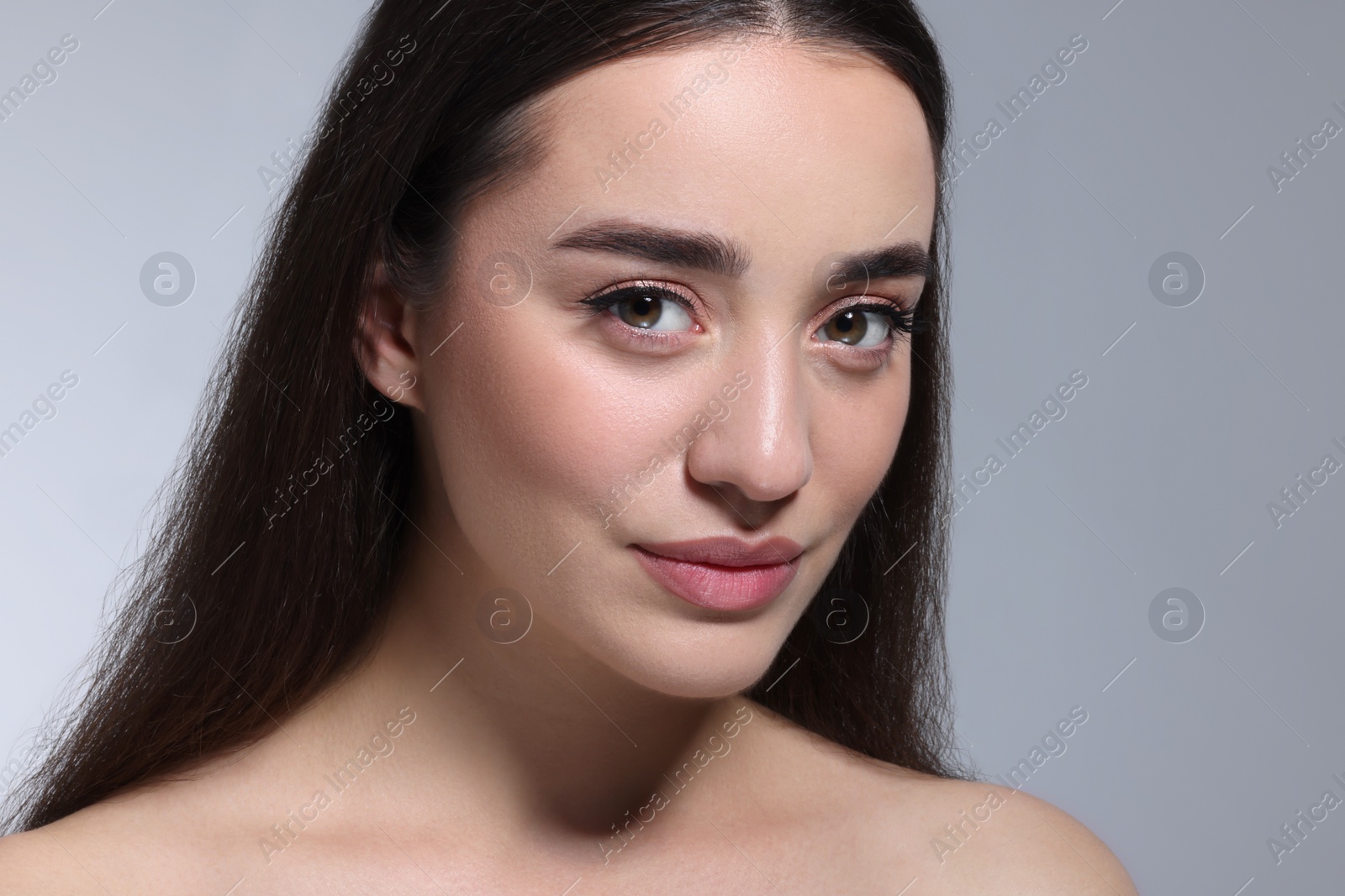 Photo of Portrait of beautiful young woman on grey background