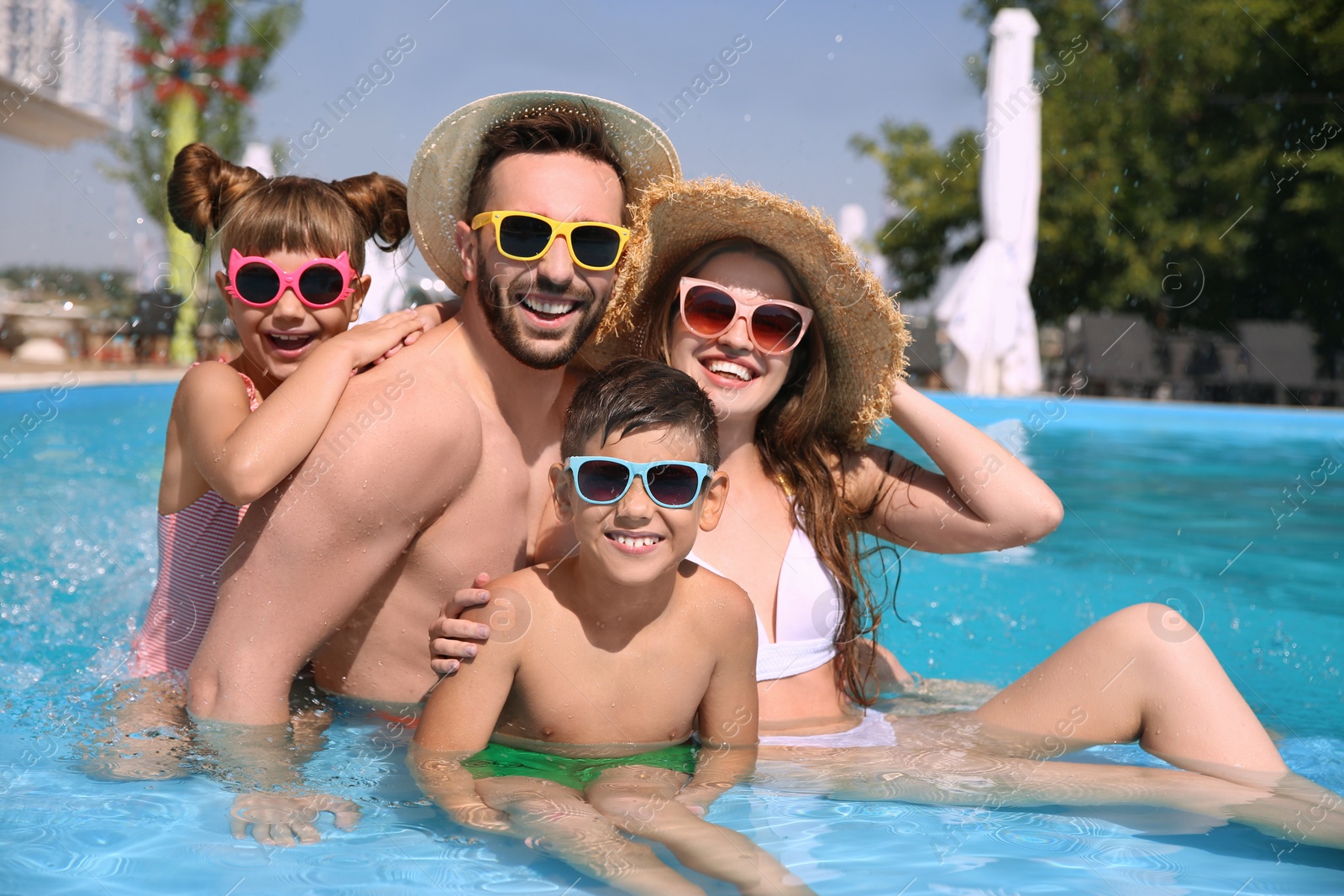 Photo of Happy family in swimming pool on sunny day