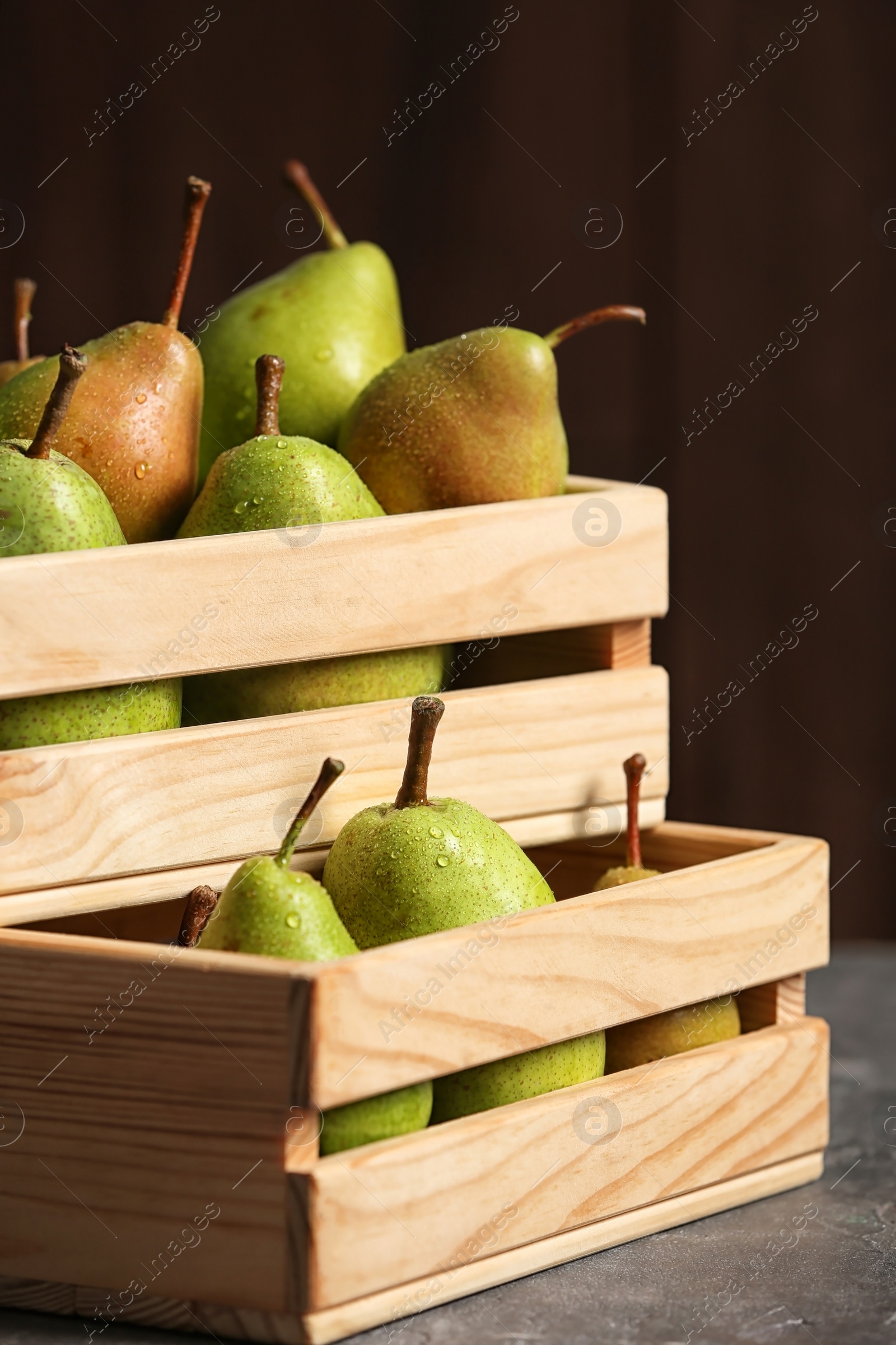 Photo of Wooden crates with ripe pears on table