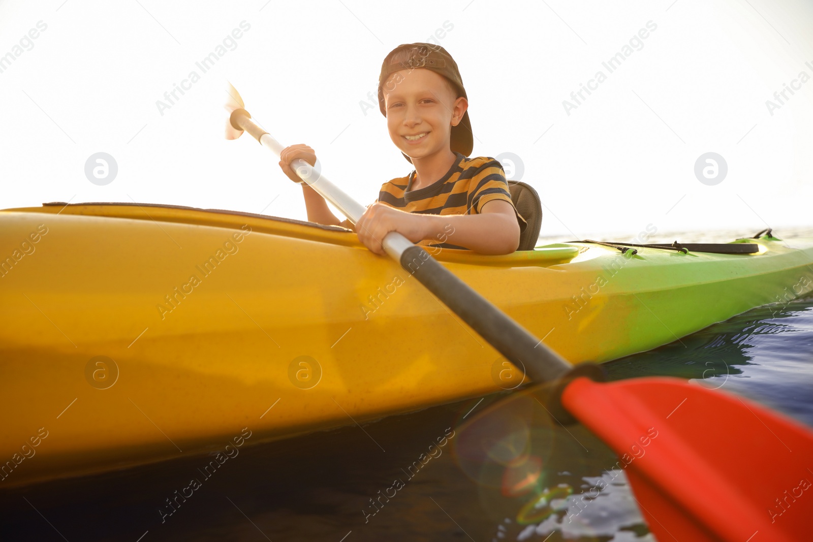 Photo of Happy little boy kayaking on river. Summer camp activity