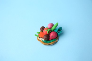 Different plasticine vegetables on light blue background. Children's handmade ideas