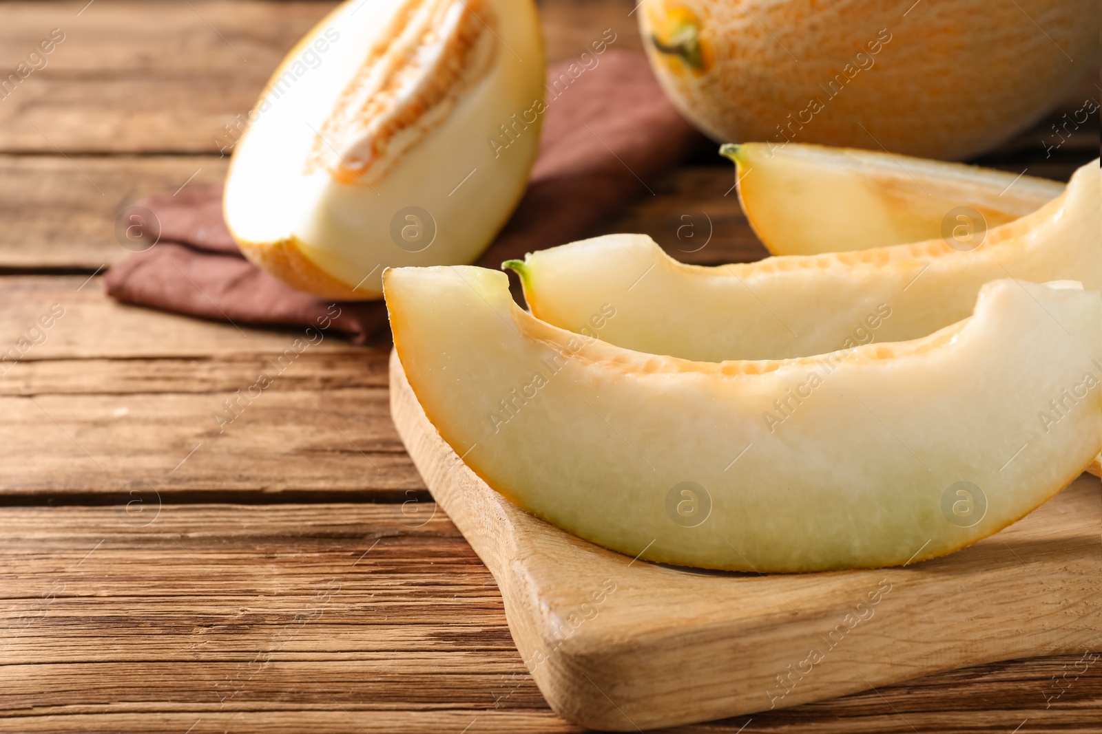 Photo of Pieces of delicious honeydew melon on wooden table