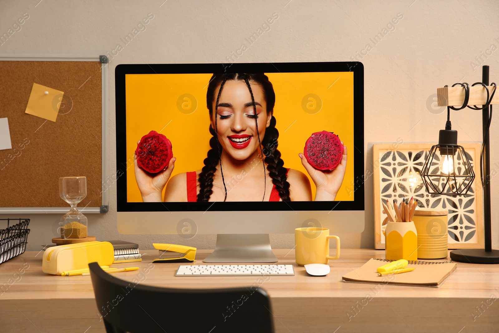 Photo of Stylish workplace with computer on wooden desk near light wall. Interior design