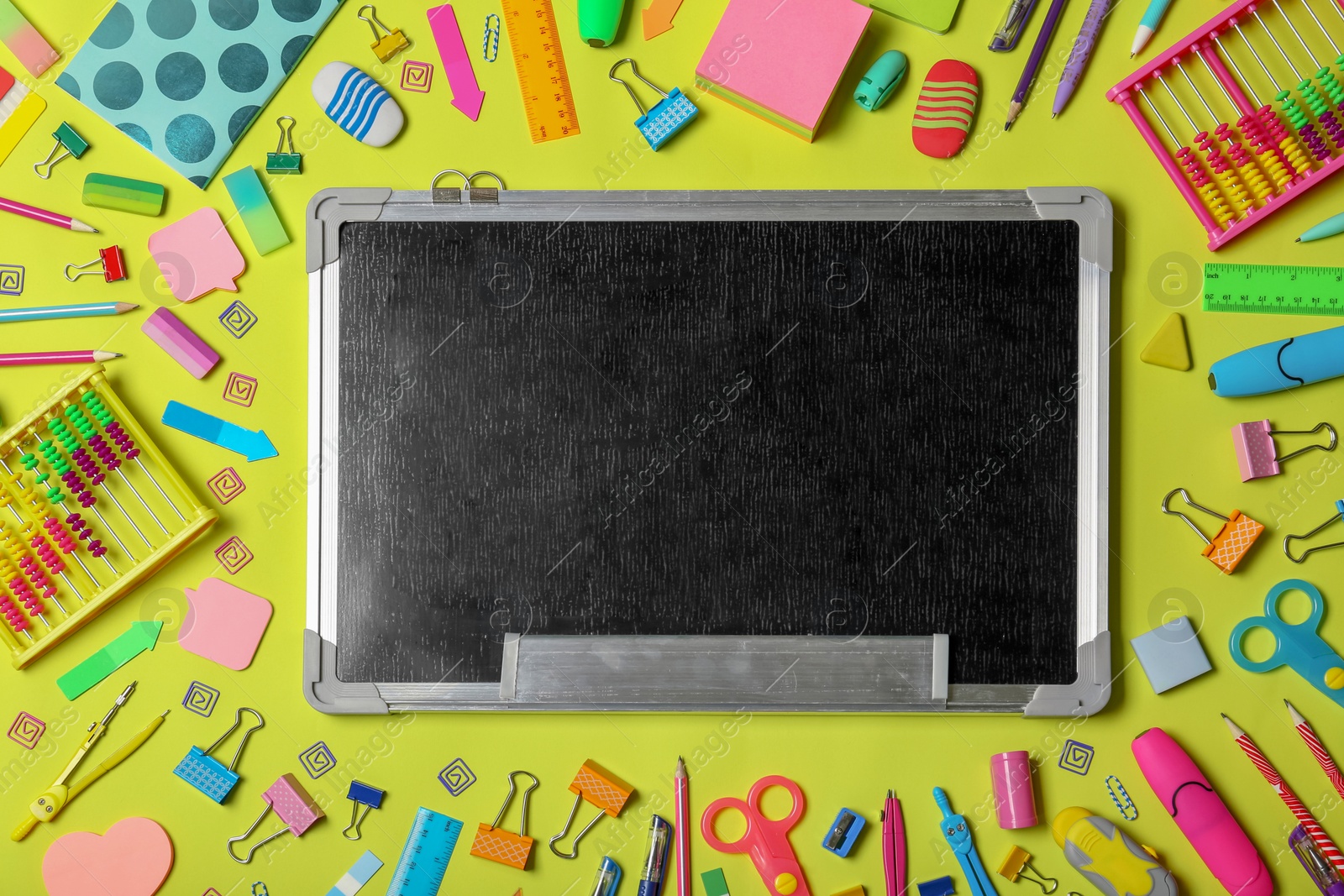 Photo of Flat lay composition with different school stationery and small chalkboard on color background