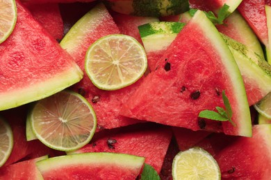 Photo of Slices of juicy watermelon with lime and mint as background, top view
