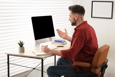 Photo of Man studying on computer at home. Online translation course