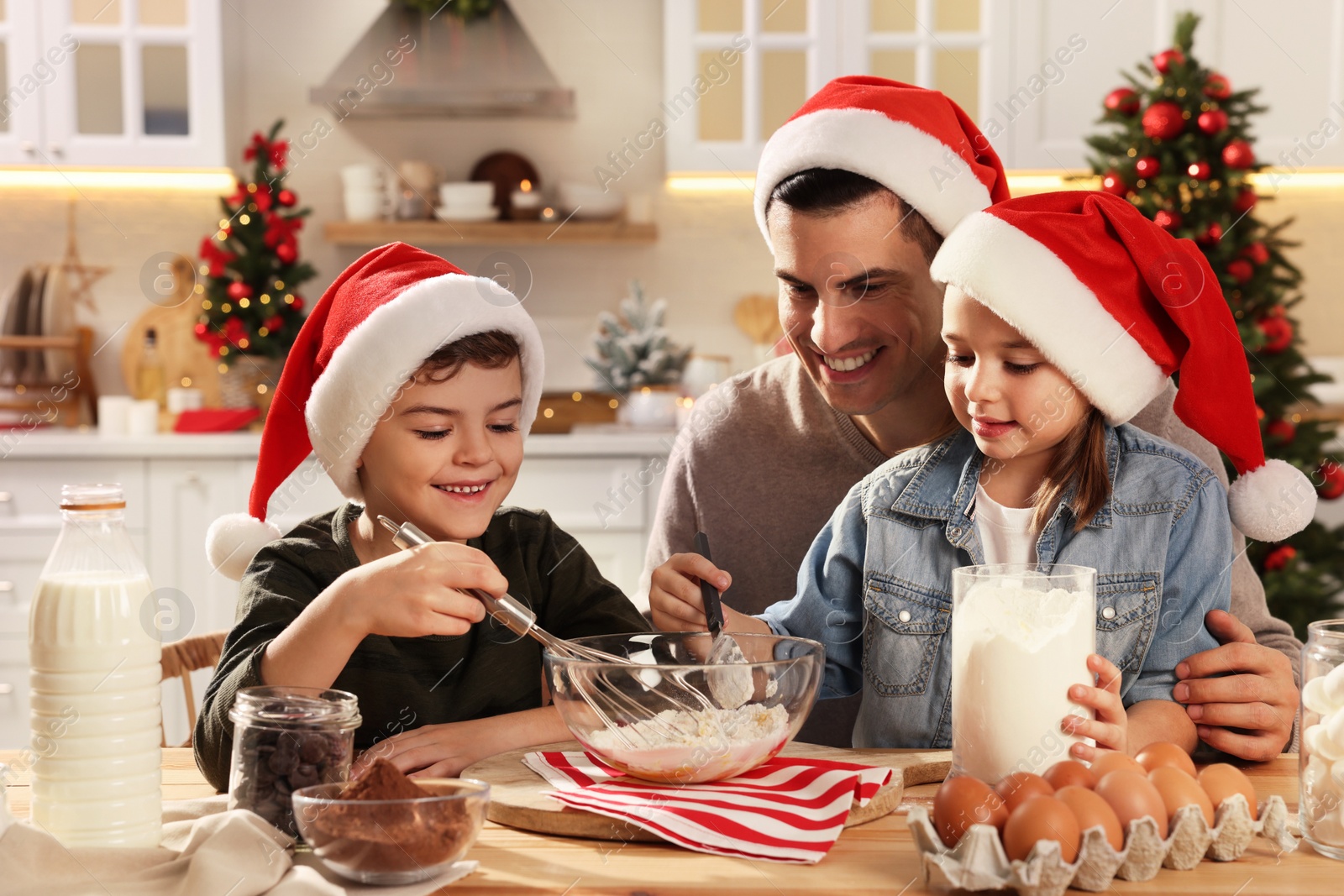 Photo of Happy father and his children making dough for delicious Christmas cookies at home