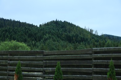 Photo of Beautiful view of mountain forest behind wooden fence