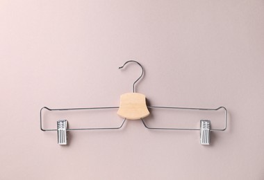 Photo of Hanger with clips on beige background, top view. Space for text