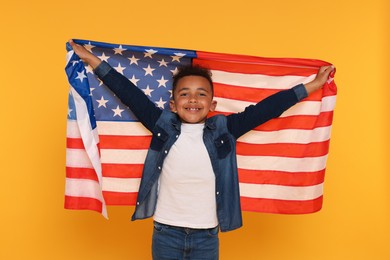 Photo of 4th of July - Independence Day of USA. Happy boy with American flag on yellow background