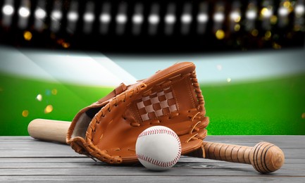 Baseball bat, glove and ball on wooden table at stadium, banner design