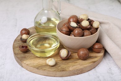 Delicious organic Macadamia nuts and natural oil on white textured table
