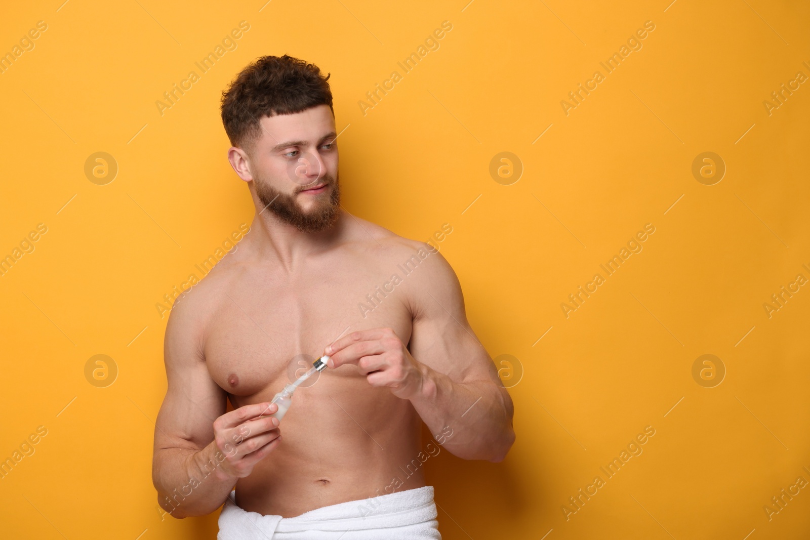 Photo of Handsome man with serum on orange background, space for text