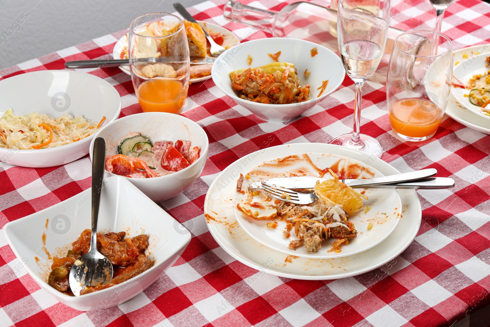 Photo of Food leftovers after party on table with checkered cloth