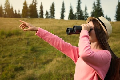 Photo of Young woman with binoculars outdoors on sunny day