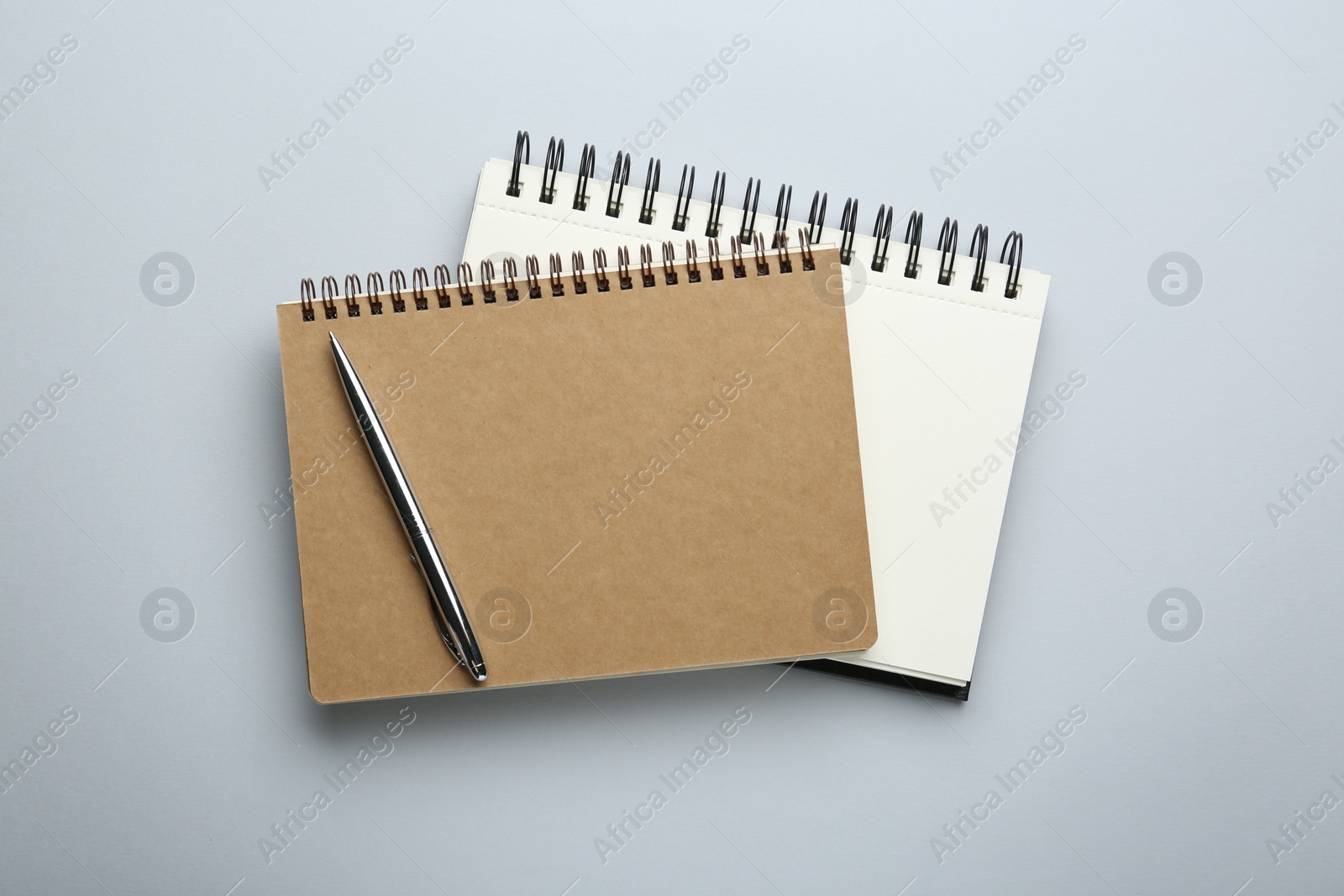 Photo of Notebooks on light grey background, top view