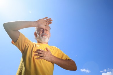 Photo of Senior man suffering from heat stroke outdoors