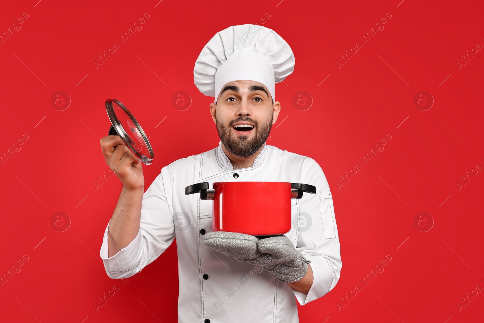 Photo of Emotional chef with cooking pot on red background