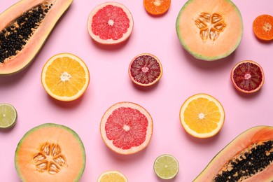 Photo of Different exotic fruits on pink background, flat lay