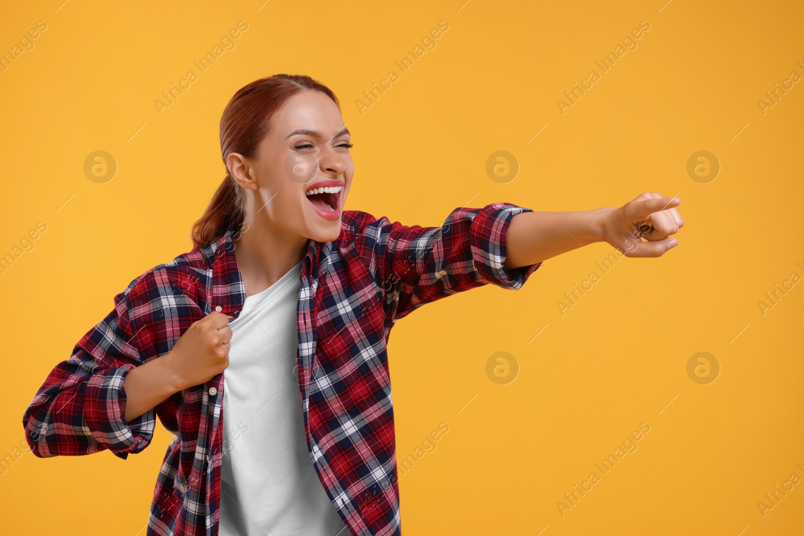 Photo of Emotional fan pointing at something on yellow background