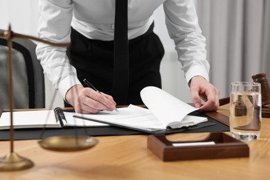 Photo of Lawyer working with documents at wooden table indoors, closeup