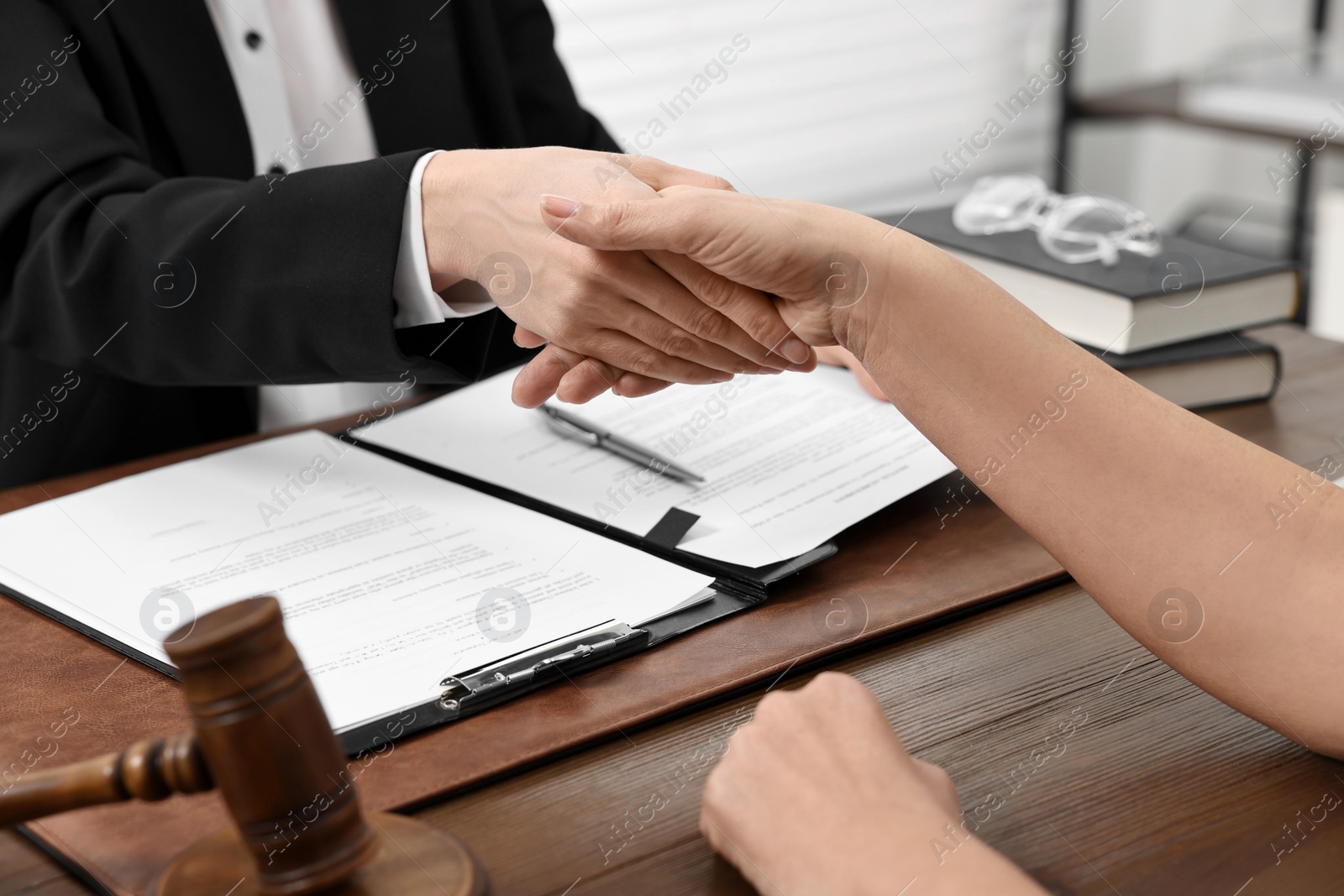 Photo of Lawyer shaking hands with client in office, closeup