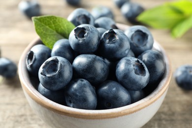 Bowl of fresh tasty blueberries on table, closeup