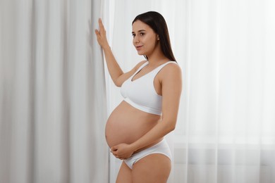 Photo of Beautiful pregnant woman in stylish comfortable underwear indoors
