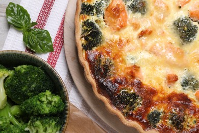 Photo of Delicious homemade quiche and ingredients on table, flat lay