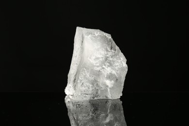 Photo of Piece of clear ice on black mirror surface