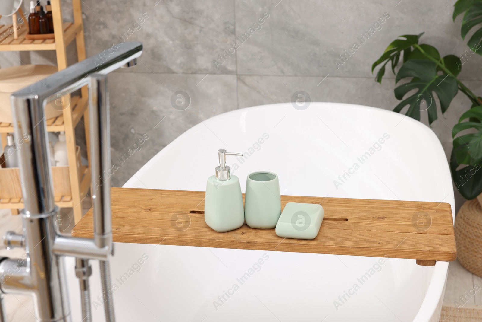 Photo of Set of bath accessories on tub in bathroom