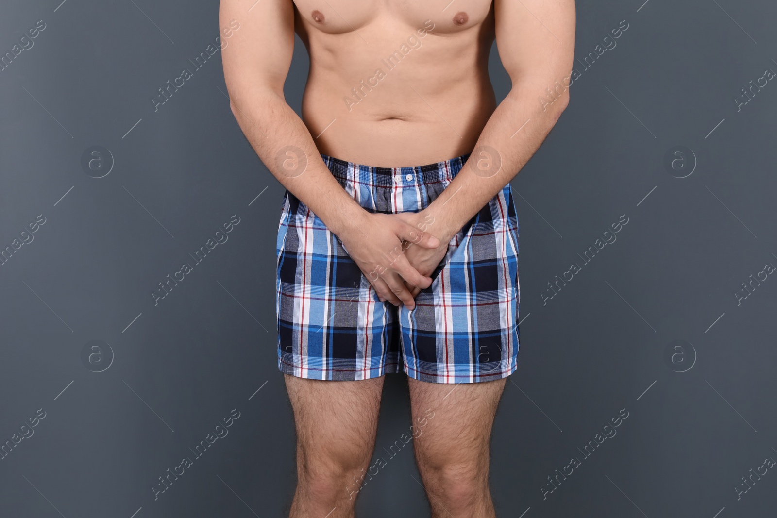 Photo of Young man with urological problems suffering from pain on grey background