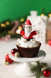 Photo of Tasty Christmas cupcake with Santa Claus figure on white table