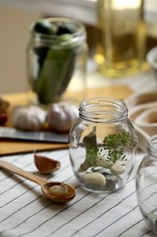 Empty glass jars and ingredients prepared for canning on table