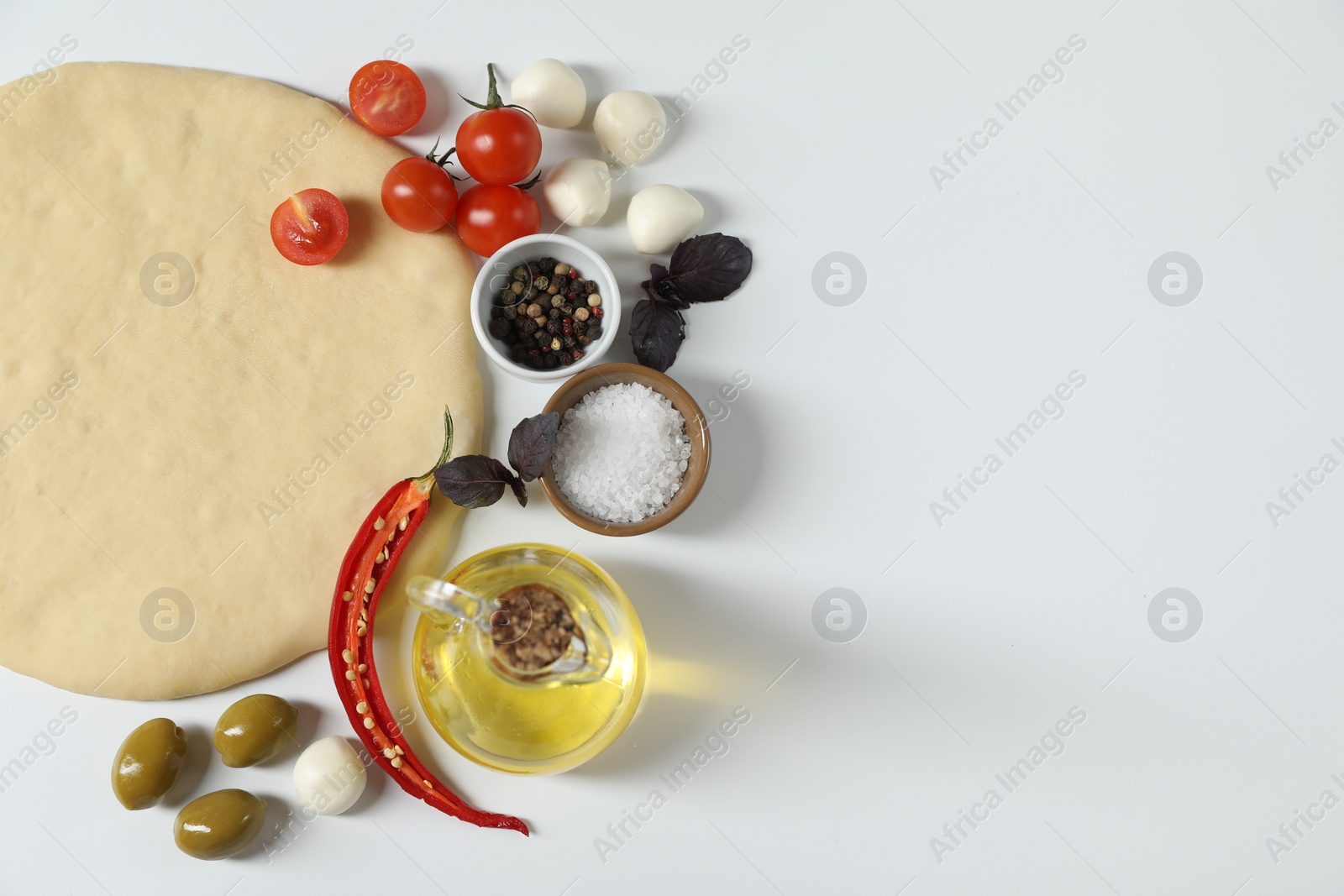 Photo of Fresh pizza dough and products on white background, flat lay. Space for text