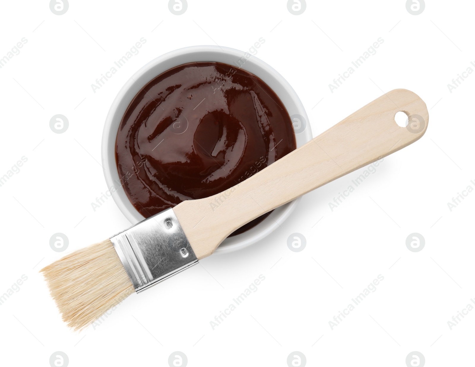 Photo of Marinade in bowl and basting brush isolated on white, top view