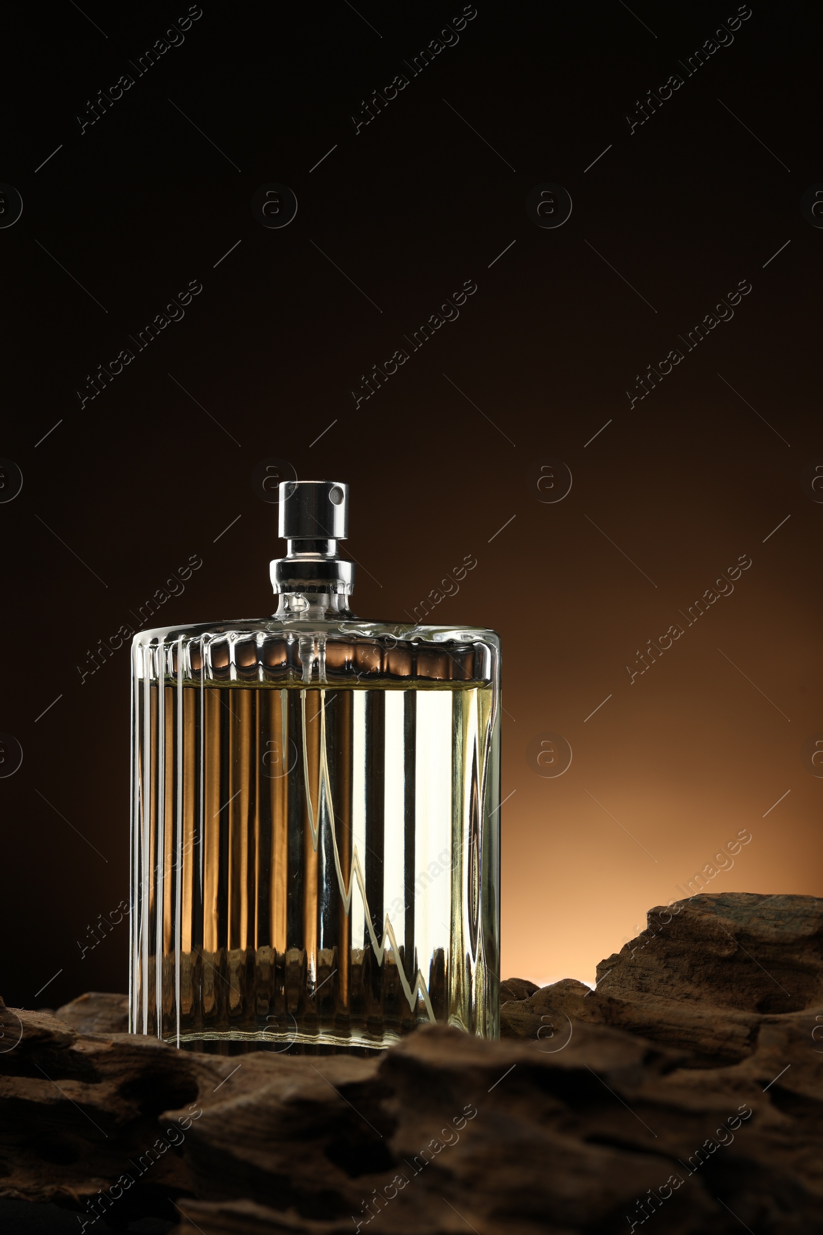 Photo of Luxury men`s perfume in bottle against brown background